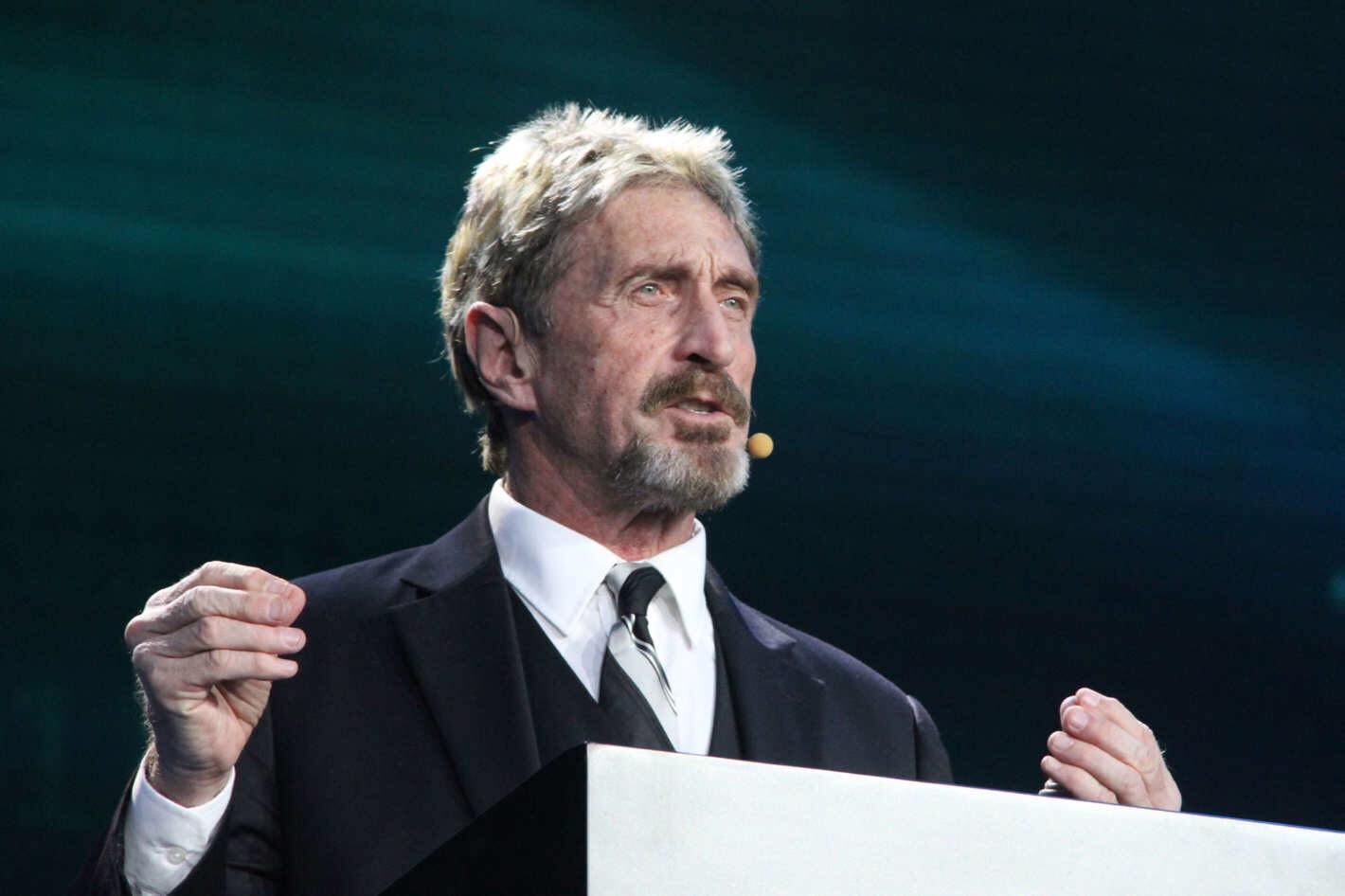 John McAfee on a podium